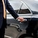 A private driver opening the door of a luxury sedan